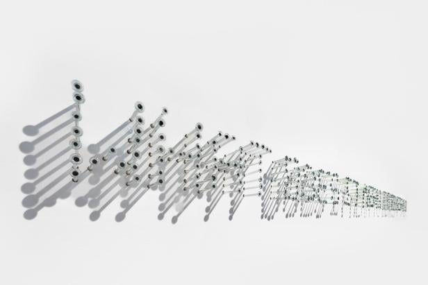 Ein Kunstwerk von Penzo + Fiore: Glasnägel werden an einer Wand befestigt und ergeben einen Satz: "What does it means to be humans?"