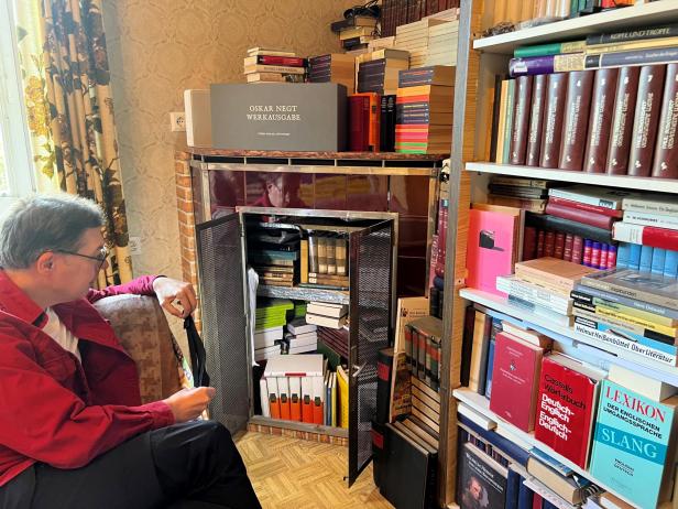 Franco Schedl sitzt vor seinen Büchern