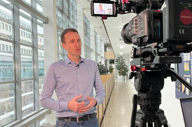 Ein Mann steht vor laufender Kamera und beantwortet Fragen.