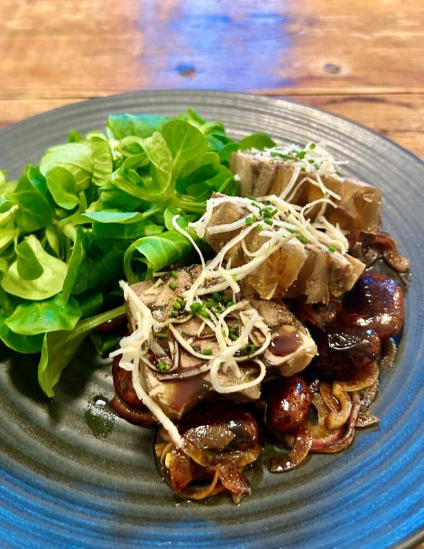 Kalbszungensulz serviert mit Käferbohnen.