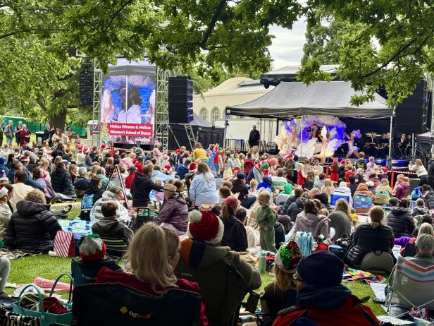 Menschen mit Santa Mützen vor einer Bühne