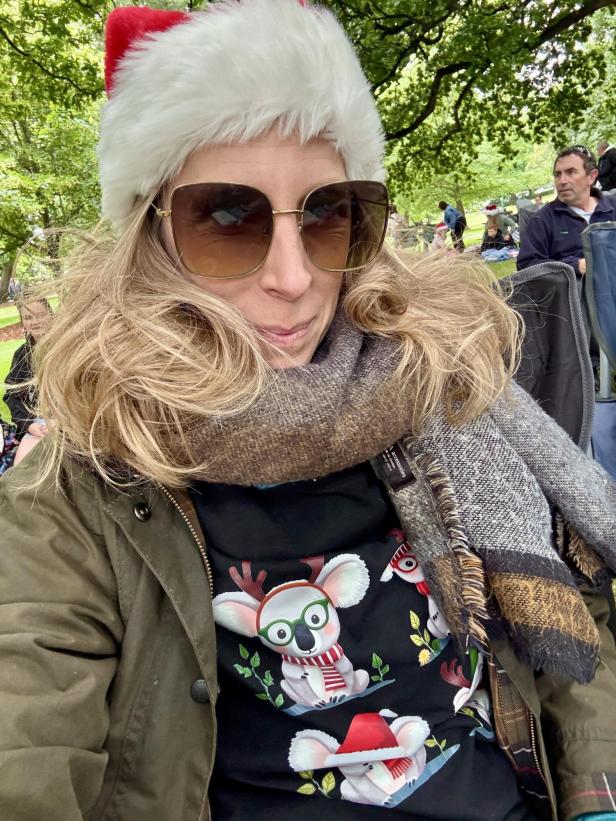 Frau mit Weihnachtstshirt und Santamütze