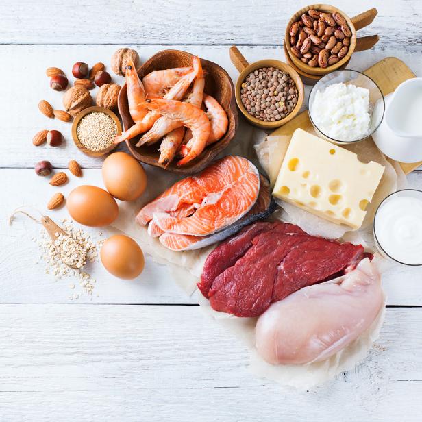 Verschiedene proteinreiche Lebensmittel wie Fisch, Fleisch, Eier, Käse, Hülsenfrüchte und Nüsse.