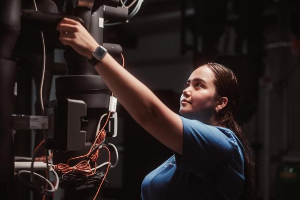 Technikerin prüft Leitungen und Anlagen in einem Gebäude bei Wartungsarbeiten.
