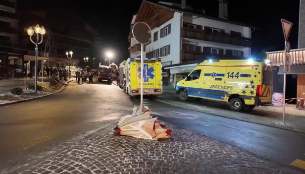 Auf einer Straße stehen bei Nacht Einsatzfahrzeuge, darunter Krankenwagen und ein Feuerwehrwagen.