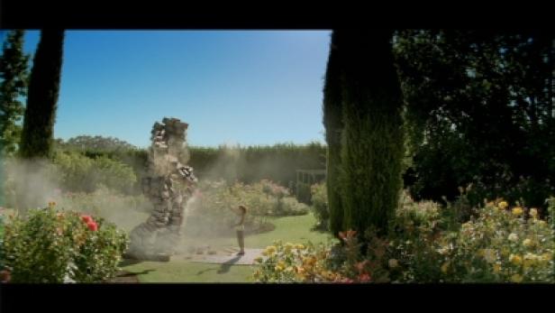 Heimat Berlin Hornbach-TV/Werde eins mit Deinem Projekt Eine Person steht vor einer Steinskulptur in einem Garten.