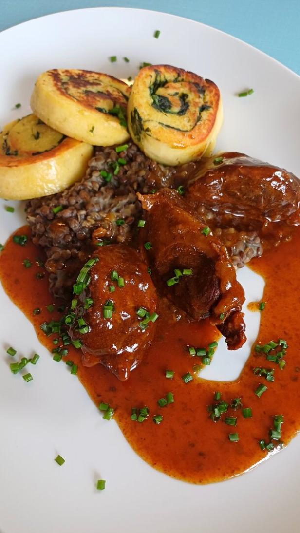 Geschmorte Schweinsbackerl mit Linsen.