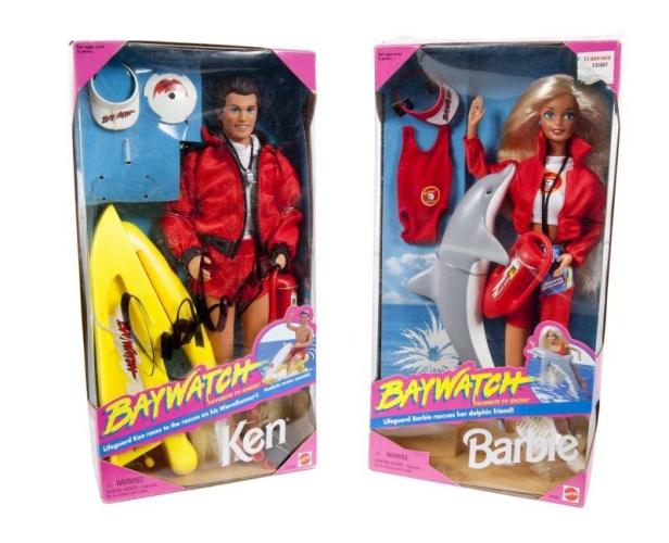Zwei „Baywatch“-Puppen, Ken mit WaveRunner und Barbie mit Delfin, in ihren Originalverpackungen.