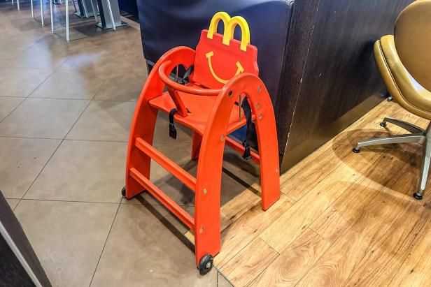 Roter Kinderhochstuhl mit gelbem McDonald's-Logo in einem Restaurant.