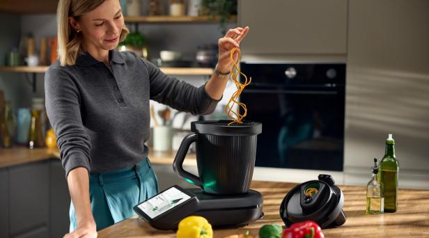 Eine Frau kocht mit einer Küchenmaschine.