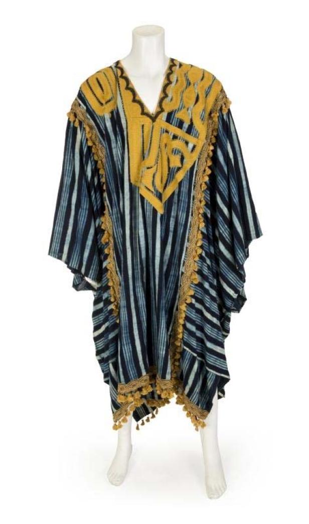 Ein blau-weiß gestreifter Kaftan mit gelben Verzierungen und Quasten auf einer Schaufensterpuppe.