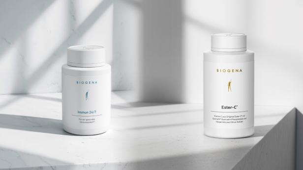 Zwei Biogena-Nahrungsergänzungsmittel-Dosen stehen auf einer hellen Oberfläche im Sonnenlicht.