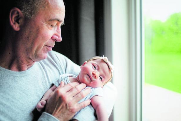 Cute newborn girl with parents and grandparents