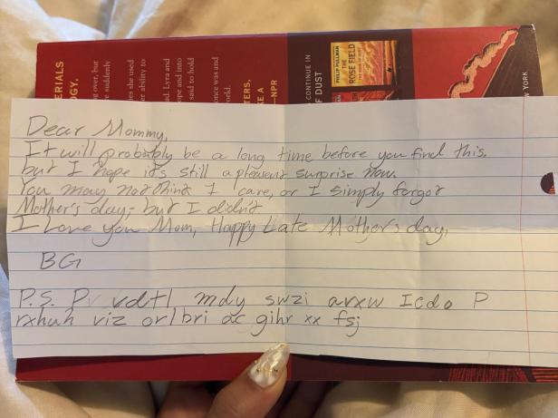 Handgeschriebener Zettel mit englischer Nachricht und verschlüsseltem Text auf linierten Papier.