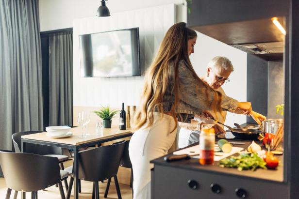 zwei frauen beim kochen in einem apartment