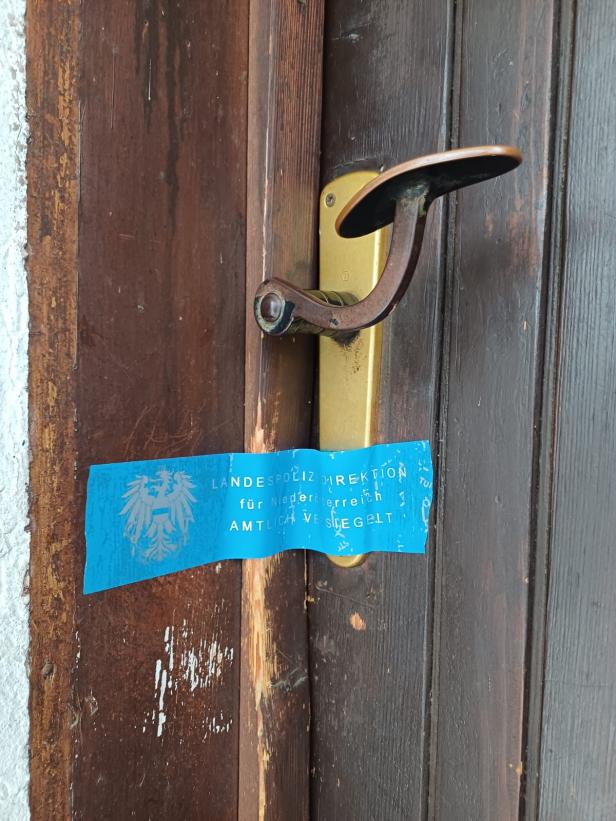 Blaues Polizeisiegel der Landespolizeidirektion Niederösterreich an einer Holztür.