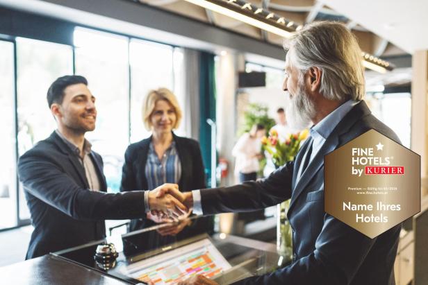 Zwei Männer im Anzug geben sich an einem Empfang die Hand, eine Frau steht im Hintergrund.