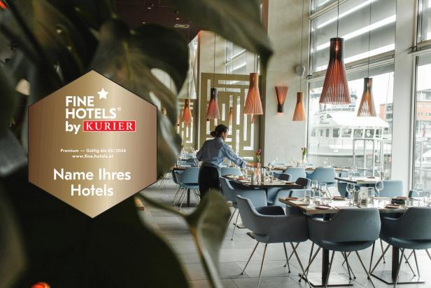 Eine Servicekraft deckt Tische in einem modernen, hellen Restaurant mit großen Fenstern.