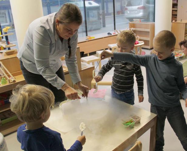 Eine Frau führt mit drei Kindern ein Experiment mit Trockeneis durch.