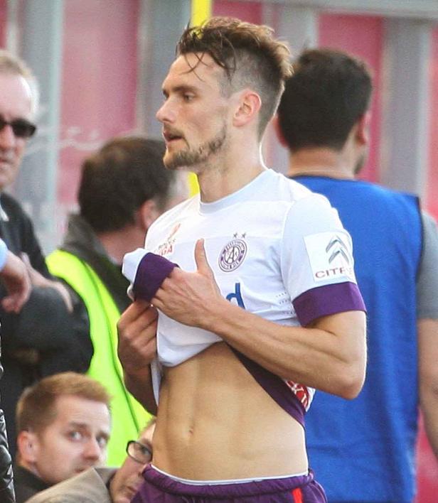 Ein Fußballspieler zieht sein Trikot hoch und zeigt seinen Bauch.