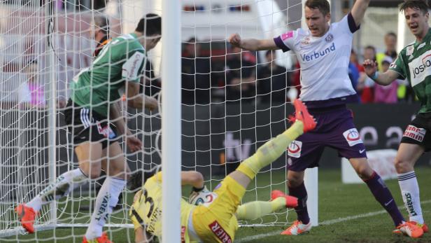 Ein Fußballspiel mit Spielern in Aktion vor einem Tornetz.