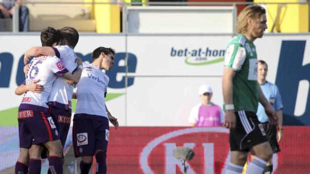 Fußballspieler umarmen sich nach einem Torerfolg.