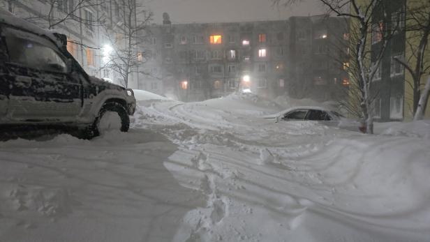 Snow covers cars and lower floors of apartment blocks in Petropavlovsk-Kamchatskiy