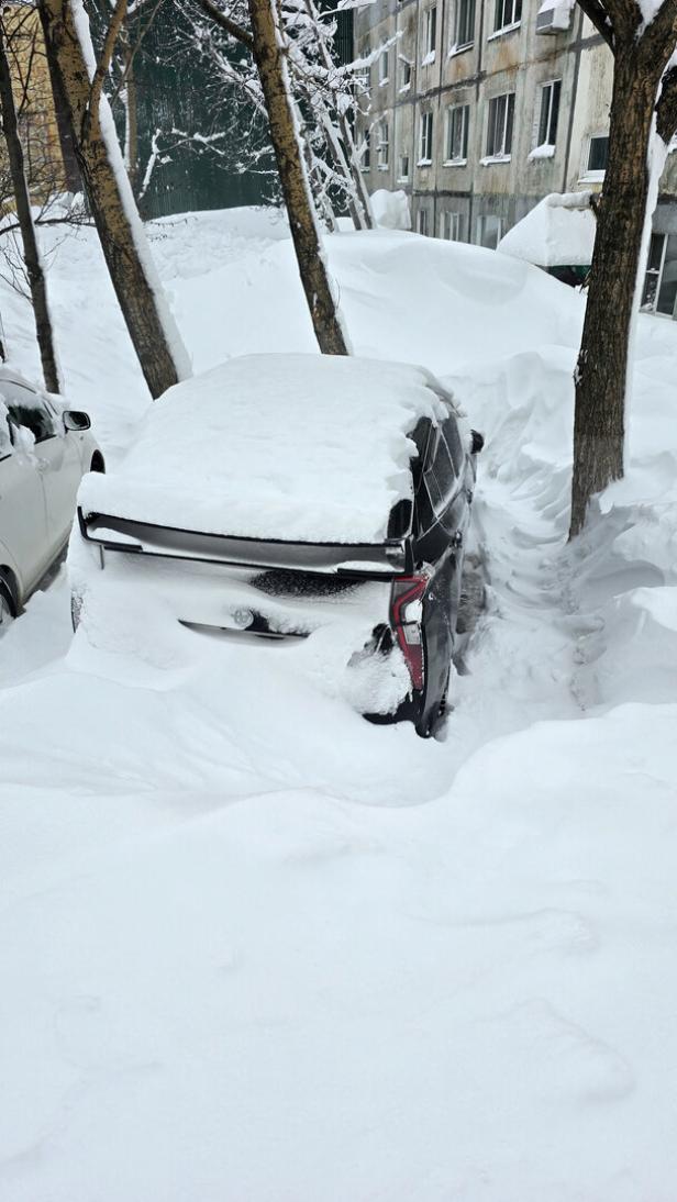 Snow covers cars in a courtyard of an apartment block in Petropavlovsk-Kamchatskiy