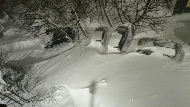 Snow covers cars in a courtyard of an apartment block in Petropavlovsk-Kamchatskiy