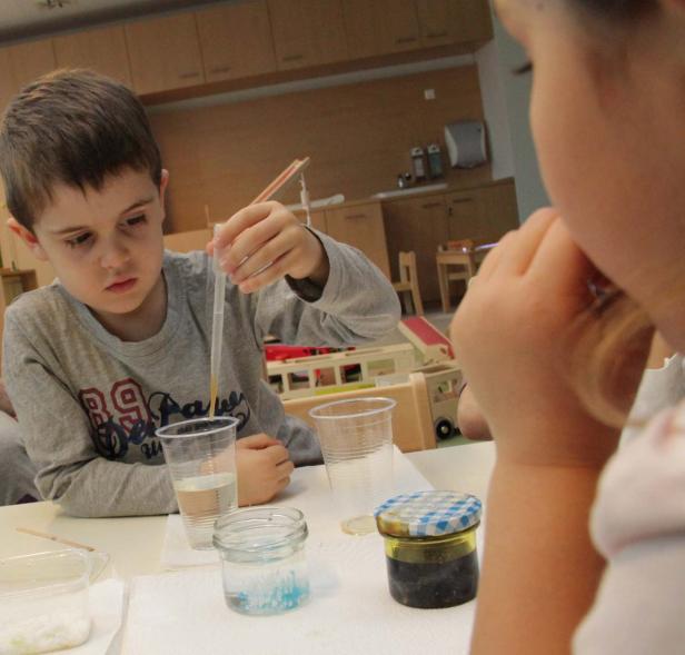 Ein Junge experimentiert mit einer Pipette und verschiedenen Flüssigkeiten.