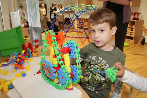 Ein Junge spielt mit einem bunten Konstruktionsspielzeug.