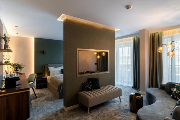 Ein schickes Hotelzimmer mit Spiegel, Bett, Sofa 