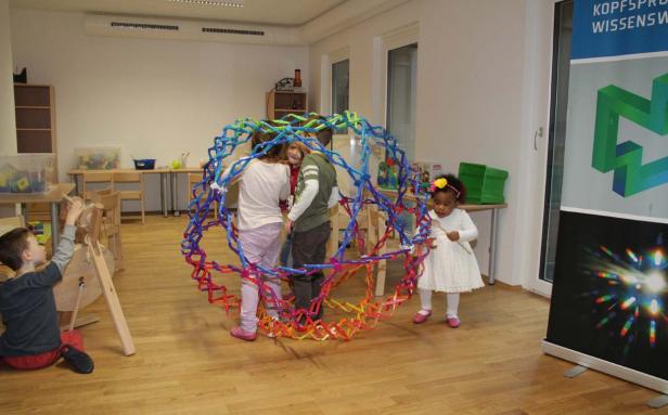 Eine Gruppe Kinder spielt mit einem großen, bunten Konstruktionsspielzeug.