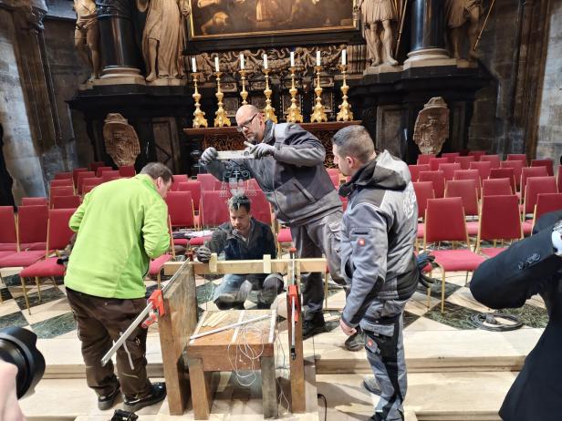 Vier Männer richten den Bischofsitz im Stephansdom ein. 