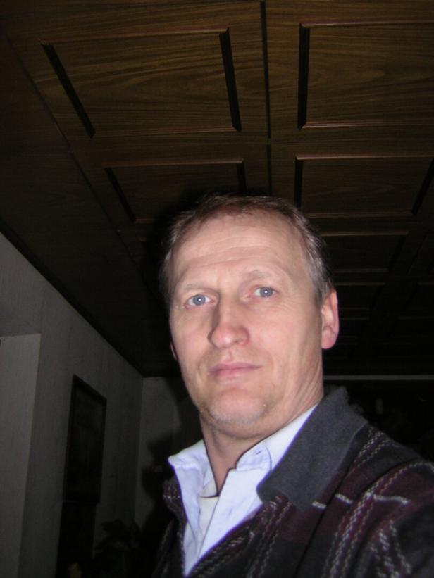 Mann mit dunkler Jacke vor dunklem Hintergrund