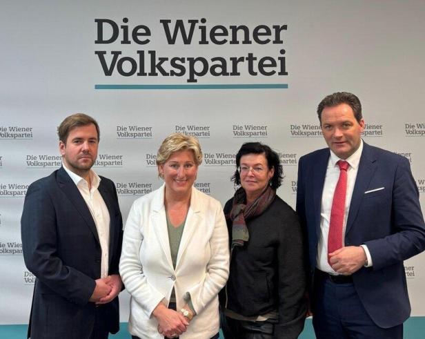 Vier Personen posieren vor dem Hintergrund der "Wiener Volkspartei".