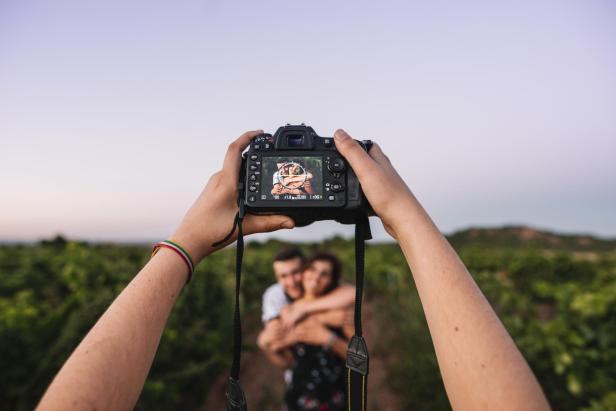 Ein Paar macht ein professionelles Fotoshooting zwischen Weinreben 