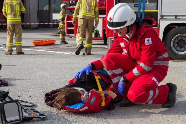 Sanitäter übt mit einer Person, die auf dem Boden liegt
