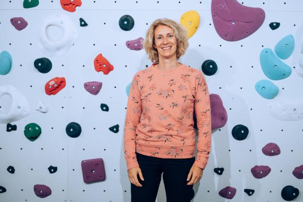 Aufnahme von Katharina Luttenberger vor eine Boulder-Wand.