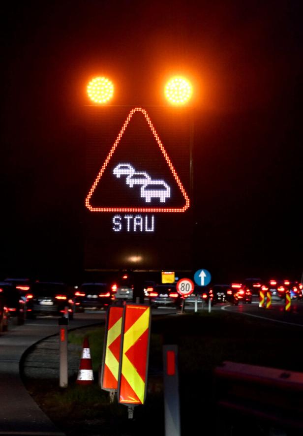 Ein Schild mit der Aufschrift "Stau" im Nachtverkehr
