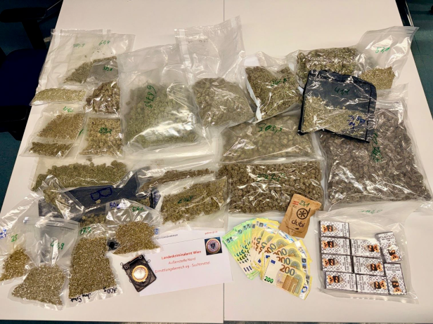 Auf dem Tisch liegen Beutel voller Cannabis, Geld und ein Ausweis des Landeskriminalamts Wien, Außenstelle Nord