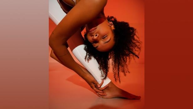 Frau macht Yoga in orange-rotem Licht