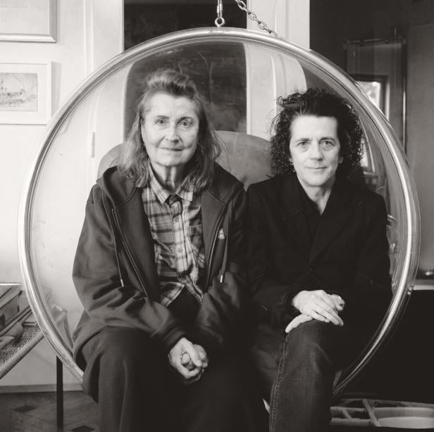 Zwei Frauen -Elfriede Jelinek und Olga Neuwirth - sitzen in einem runden Hängesessel und schauen in die Kamera.