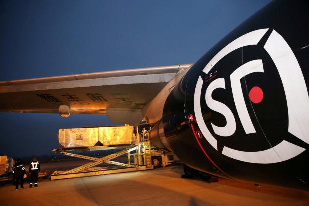 FILE PHOTO: Employees load goods into a cargo aircraft of SF Airlines, owned by SF Express Co, after the Singles Day online shopping festival, at Nantong airport in Nantong
