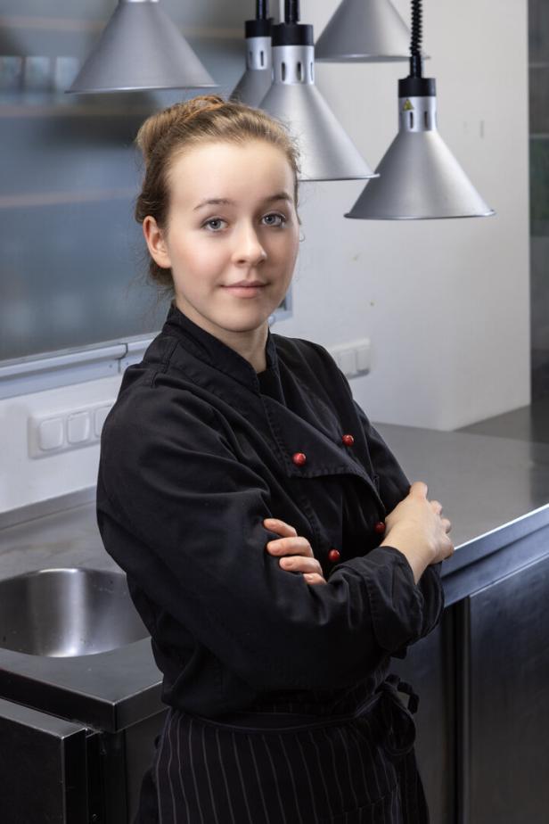 Eine Frau in Kochuniform steht in einer Küche