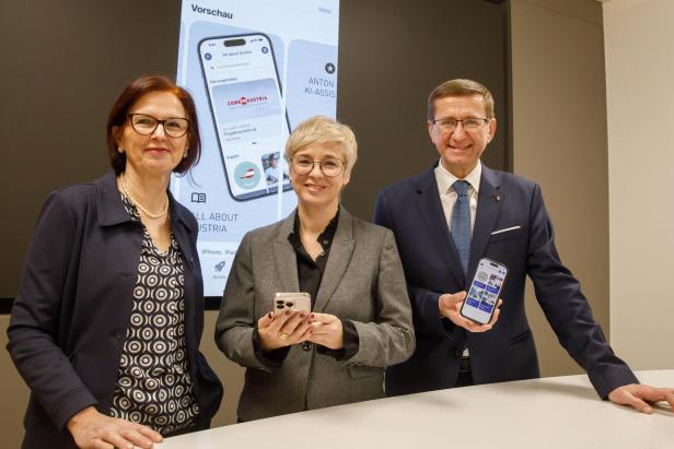 Zwei Frauen und ein Mann halten Handys in die Kamera