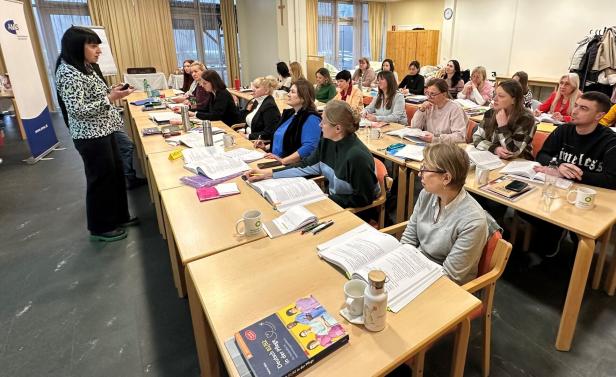 Ein Saal voller Menschen, die an einem Kurs teilnehmen