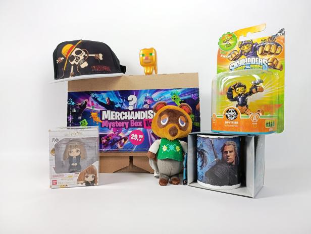 Verschiedene Fanartikel aus Videospielen, Filmen und Serien vor einer Mystery Box arrangiert.