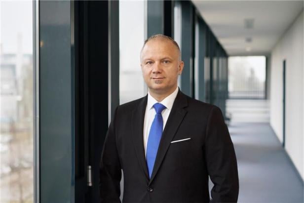 Mann mit schwarzem Anzug und blauer Krawatte