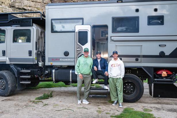 Drei Männer vor einem Wohnwagen